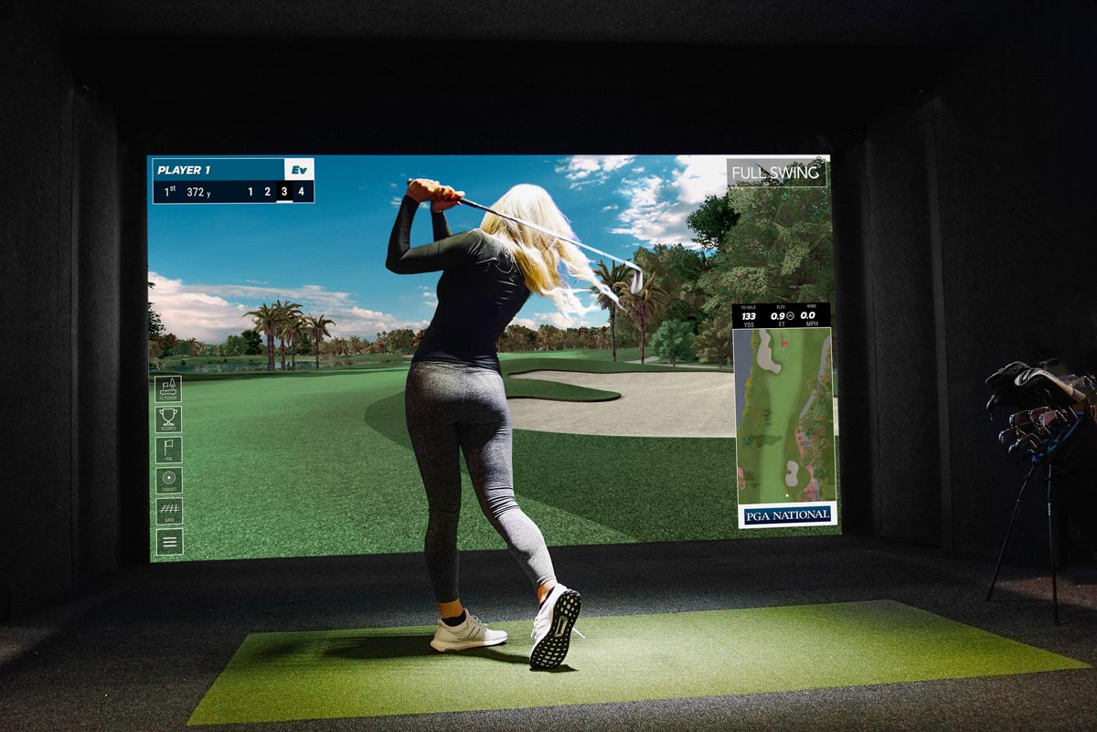 Golfer teeing off on a Full Swing simulator at Golfer's Den