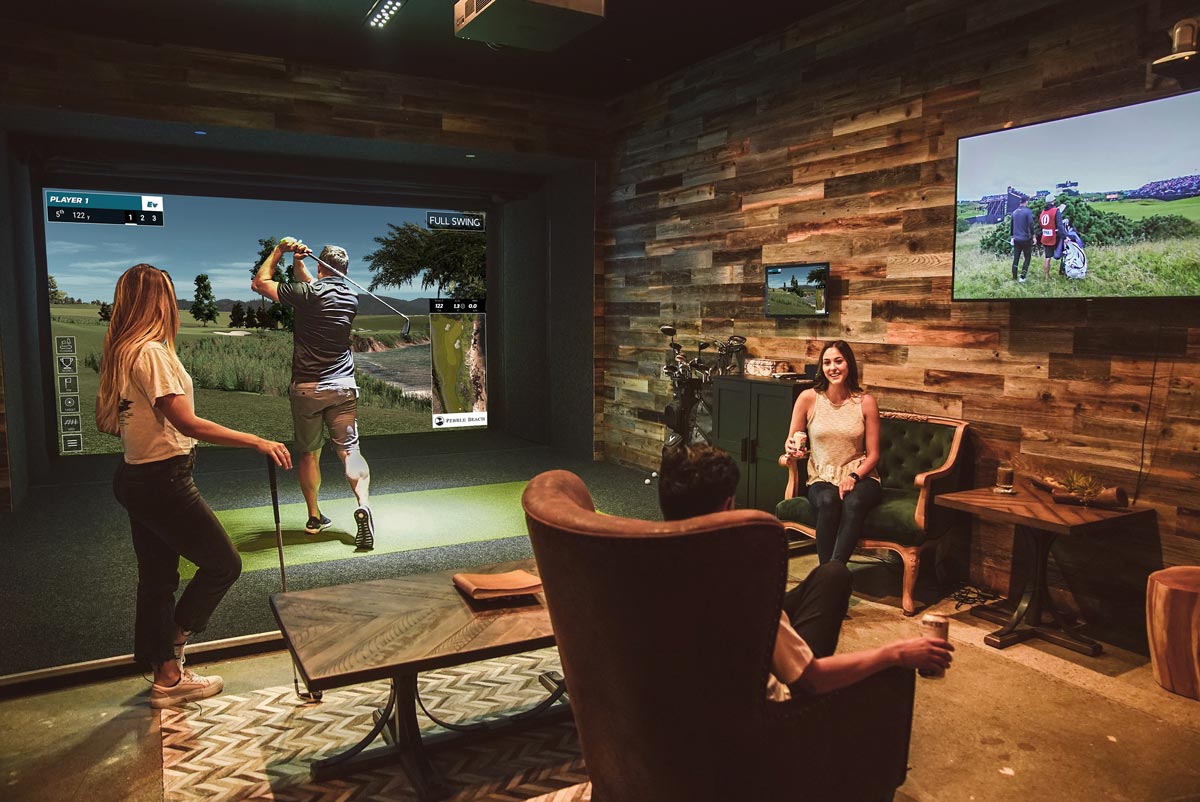 Group celebrating around a simulator bay at Golfer's Den